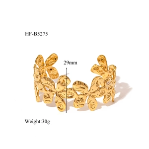 Macro view of 29mm wide gold flower cuff bracelet showing 30g weight and textured metal