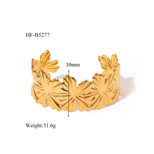 Macro view of 30mm wide 18K gold plated steel cuff featuring floral patterns