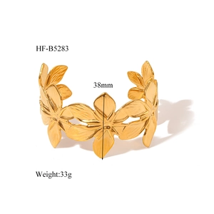 Detail view of 38mm wide gold floral cuff bangle with 3D embossed flower pattern