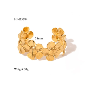 Detail of 18K gold-plated floral cuff bracelet showing 28mm width and daisy pattern