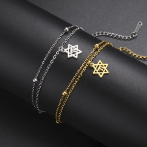 Gros plan de bracelets Chai Etoile de David en or et argent sur un support noir