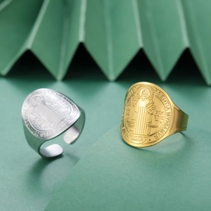 Primer plano de los anillos de San Benito en oro y plata con grabado en relieve fino