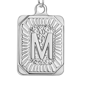 Detail van zilveren rechthoekige hanger met letter M en rand met steenachtige textuur