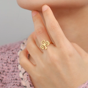 Detail eines goldenen Kleeblatt-Rings mit keltischem Knoten an einem Frauenfinger