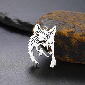 Vintage stainless steel wolf head pendant with hollow design on natural stone background