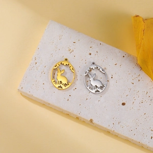 Detail view of hollow bunny pendants in gold and silver finish on stone surface