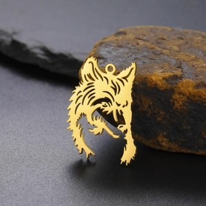 Golden hollow wolf head stainless steel pendant displayed on a natural brown stone
