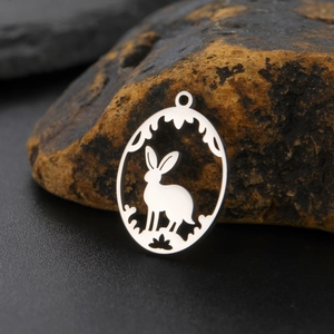 Detailed macro view of the rabbit and plant cutout design on a silver stainless steel pendant