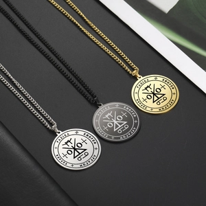 Dettaglio di collane con sigillo arcangelo in oro, argento e nero su sfondo di pelle scura