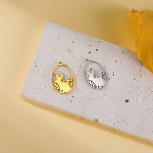 Macro shot of silver and gold rabbit in flower pendants on a textured stone slab
