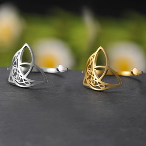 Λεπτομερής όψη χρυσών και ασημένιων κέλτικων δαχτυλιδιών σε σκούρα πέτρινη επιφάνεια