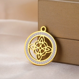 Golden stainless steel Celtic knot pendant with sparkling rhinestones on a jewelry box