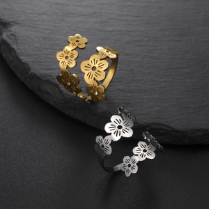 Elegant cherry blossom open rings in gold and silver finish on black stone background