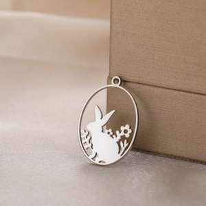Polished stainless steel oval rabbit in flower field pendant on champagne silk background