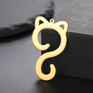 Detailed view of gold-plated cat outline pendant on dark textured stone background