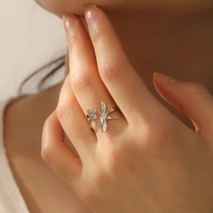 Adjustable stainless steel open ring with dragonfly and flower design on a hand