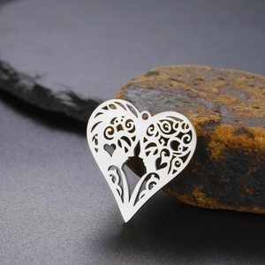 Macro shot of silver cutout heart pendant with intricate filigree on raw stone