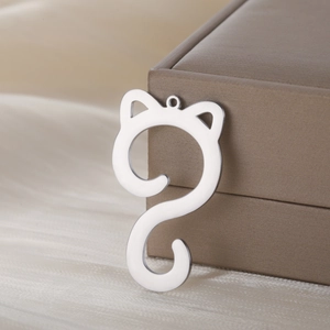 Polished silver stainless steel cat pendant with minimalist design on satin backdrop