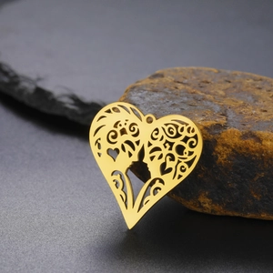 Detailed macro view of a golden hollow heart pendant with artistic silhouette patterns