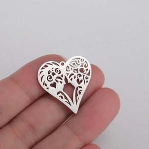 Hollow heart pendant in stainless steel with romantic face silhouettes held by fingers