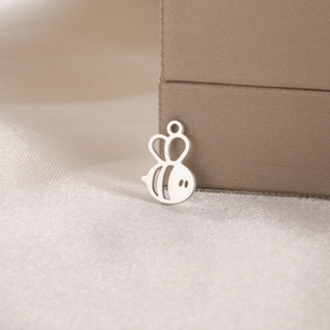 Close-up of hollowed-out bee charm pendant made of polished steel for jewelry making