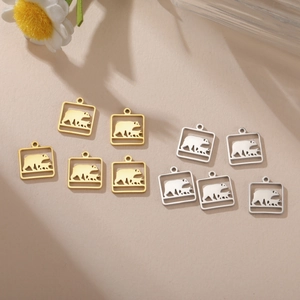 Detailed view of polar bear silhouettes in gold and silver square metal pendants