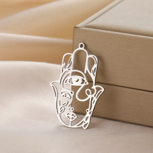 Abstract Hamsa hand pendant in stainless steel with face design on champagne silk fabric