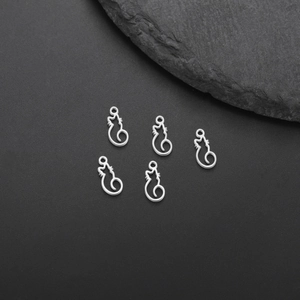 Detailed macro view of five minimalist silver cat outline charms for DIY jewelry making