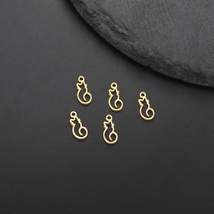 Detailed view of five golden stainless steel cat silhouette charms on black texture