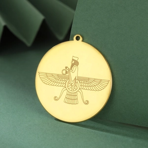 Macro shot of 18K gold plated Faravahar round pendant on green background display