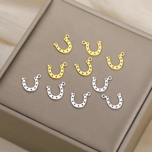 Macro view of gold and silver stainless steel horseshoe charms on a textured jewelry box