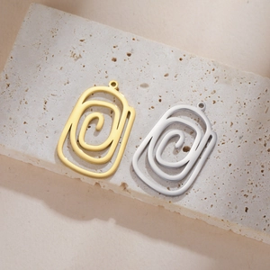 Vue détaillée des pendentifs spirales polis en or et argent pour la création de bijoux