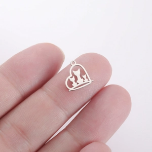 Macro shot of silver heart-shaped cat silhouette pendant held by hand for size reference