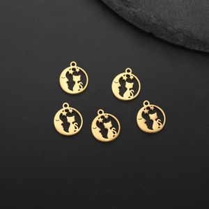 Detailed view of gold-plated cat and moon pendants on a black textured background