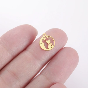 Close-up of a small golden cat and moon cutout pendant held by hand for scale