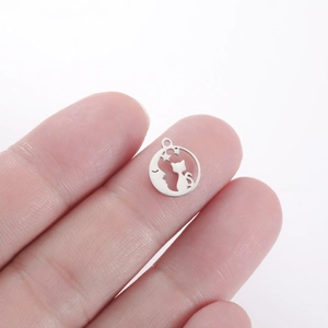 Close-up of a mini stainless steel cat and moon hollow pendant for DIY jewelry making