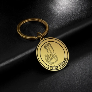 Macro shot of gold Ace of Swords tarot keychain with polished crown and sword details