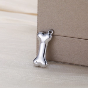 Macro view of polished stainless steel dog bone charm pendant for jewelry making