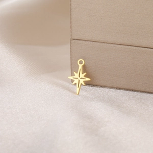 Macro shot of a polished gold eight-pointed star pendant on soft champagne silk fabric