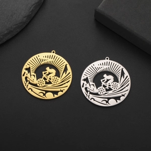 Detail view of gold and silver bicycle pendants with sun and mountain cutouts on black stone