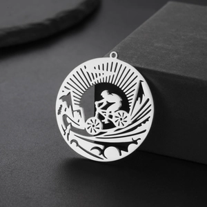 Macro detail of round cutout cycling pendant in polished stainless steel for DIY jewelry