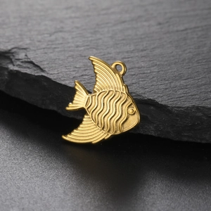 Golden stainless steel tropical fish pendant with textured details on a slate background