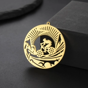 Macro shot of gold-plated hollow cycling pendant with detailed rider silhouette for DIY jewelry