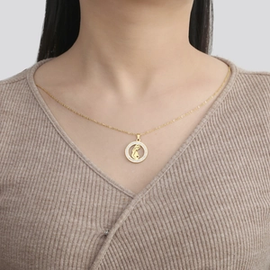 Gros plan d'un collier doré maman et bébé avec pavé de zircons brillants sur modèle