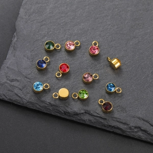 Detailed view of colorful round birthstone pendants with gold plated stainless steel edges