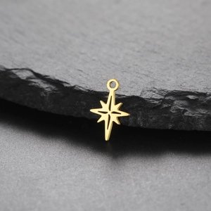 Gold eight-pointed star pendant on dark stone background for DIY jewelry making