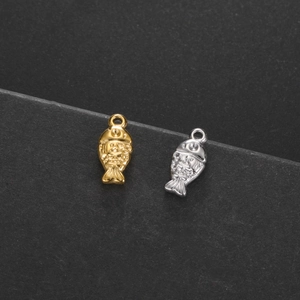 Detailed view of fish-shaped metal charms with textured scales in gold and silver finish