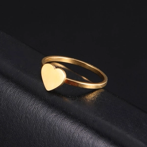 Minimalist gold heart ring in polished stainless steel shown on a black leather stand