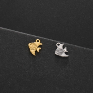 Close-up of golden and silver fish charms with wavy textures for DIY jewelry making