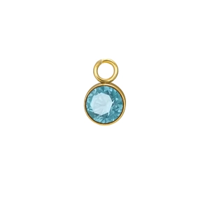 Macro shot of light blue round faceted birthstone pendant with gold bezel setting